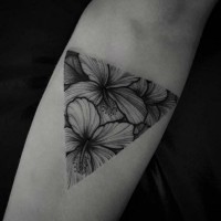 Tatuaje en el antebrazo, flores exóticas en triángulo, dibujo monocromo