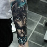 Schöne Frau und Kopf des Wolfs Tattoo am Unterarm