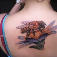 Bee sitting on flower tattoo on back