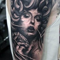 Big 3D like black ink Medusa shoulder tattoo with diamond