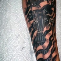 Tatuaje en el antebrazo,
parte de guitarra simple, tinta negra