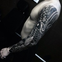 Tatuaje en el brazo completo, 
pez carpa grande con flores diferentes, colores negro blanco