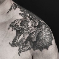 Big black and white animal skull with flowers and leaves tattoo on shoulder