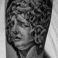 Big black and white antic Medusa statue tattoo on arm