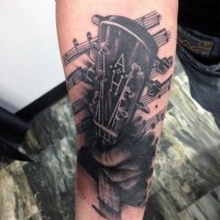 Tatuaje en el antebrazo, mano que toca la guitarra y notas musicales