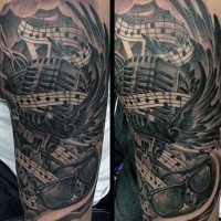 Großes schwarzes und weißes Mikrofon mit Musiknoten und Gläsern Tattoo am Arm