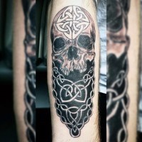 Big black and white mystical skull stylized with Celtic ornaments tattoo on arm