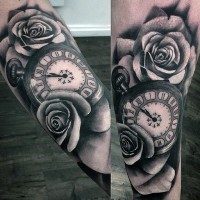 Big black and white old clock with flowers tattoo on arm