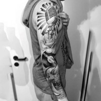 Big black and white very detailed music themed tattoo on sleeve