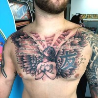 Big black ink Christian tattoo with angel and lettering on chest
