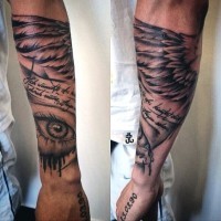 Big black ink memorial tattoo with lettering and wing on arm
