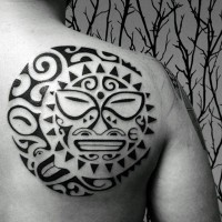 Big black ink Polynesian sun tattoo on shoulder