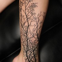 Großer schwarzer realistischer Wald Tattoo am Knöchel