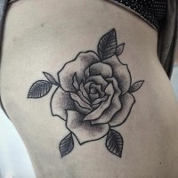 Großes schwarzes übliches  Tattoo am Oberschenkel mit Blättern und Rose