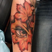 Großes farbiges natürliches Blatt mit mystischem Auge Tattoo am Arm