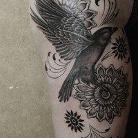 Tatuaje en el muslo, ave divina con flores diferentes