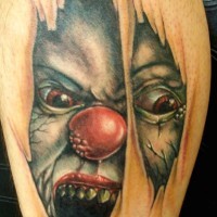 Big colored terrifying leg tattoo of under skin monster clown