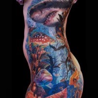Tatuaje en las costillas de un gran tiburón coloreado y los habitantes del mar.