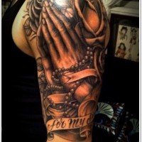 Big detailed black and white praying hands with lettering and flowers tattoo on shoulder