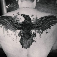 Big detailed black ink flying crow tattoo on upper back