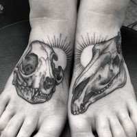 Big dot style feet tattoo of animal skull with sun