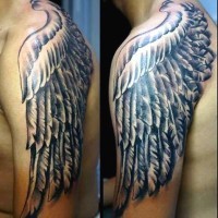 Big fantasy style painted black and white wing tattoo on shoulder