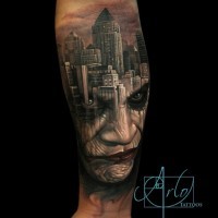 Großes Unterarm Tattoo mit städtlichen Sehenswürdigkeiten und Joker Porträt