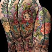 Große im illustrativen Stil farbige Matroschka mit Blumen und Vögeln Tattoo am Ärmel