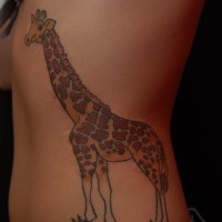 Big ink painted giraffe tattoo on grass