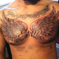 Big memorial style black ink wings with lettering tattoo on chest with wings