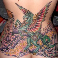 Tatuaje  multicolor en la espalda baja, unicornio fantástico con castillo y montón de estrellas