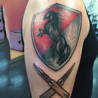 Big multicolored shield with horse and bullets tattoo on upper arm