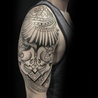 Big mystical designed upper arm tattoo fo human skulls with flowers
