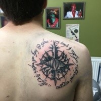 Big mystical looking black ink shoulder tattoo of Lord of the Rings symbol and lettering