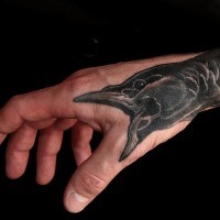 Tatuaje en la mano,  cuervo amenazante que grita