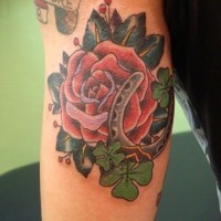 Big red rose with clover and horseshoe tattoo on arm