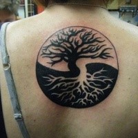 Big size black and white Asian Yin Yang symbol stylized with trees tattoo on upper back