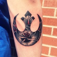 Big usual shaped Rebel Alliance emblem tattoo on forearm stylized with flower
