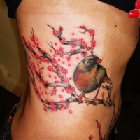 Tatuaggio sul fianco l'uccello sul ramo fiorito