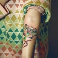 Bird and photo camera tattoo on arm