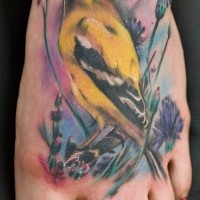 Tatuaje en el pie, ave amarilla en la hierba