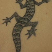 El tatuaje de color gris y negro de una lagartija