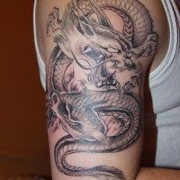 Tatuaggio sul braccio il dragone con la bocca spalancata