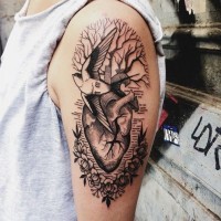 Tatuaje en el brazo, corazón y ave, árbol y flores