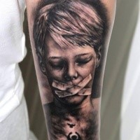 Black and gray horror style medium size boy with taped mouth tattoo on forearm