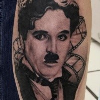 Black and gray style arm tattoo of Charlie Chaplin