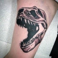 Black and gray style biceps tattoo of dinosaur skeleton