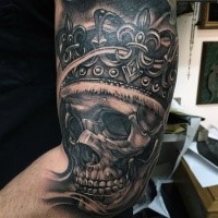 Black and gray style biceps tattoo of king skull with crown
