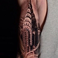 Black and gray style colored arm tattoo of Empire State building