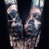 Black and gray style colored arm tattoo of woman face with skull